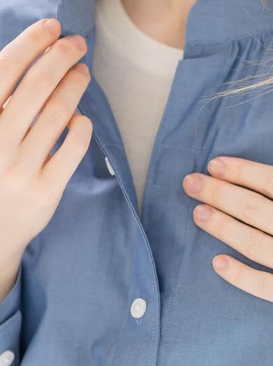 Woman buttoning shirt